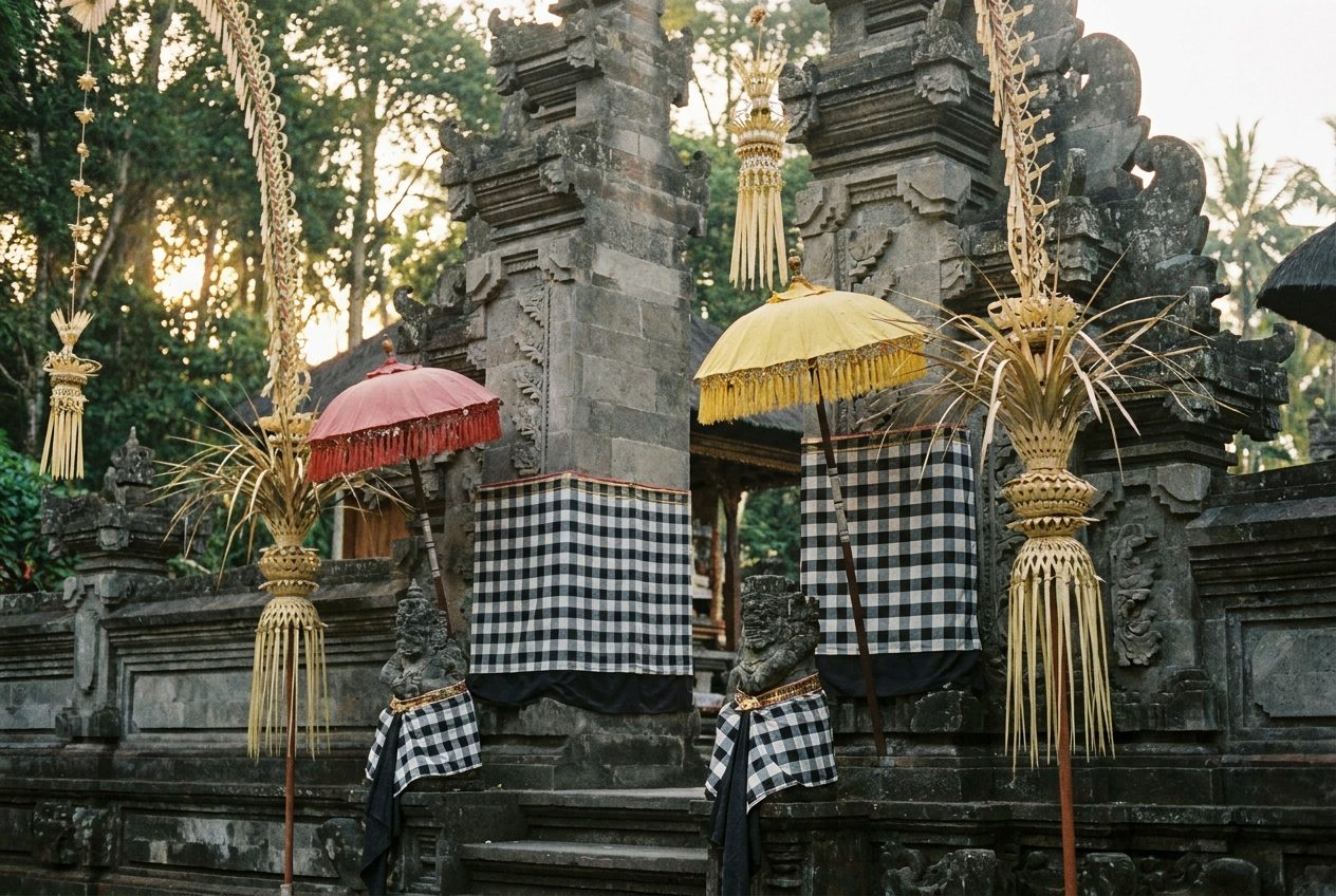 Balinese stone temple gateway dressed with poleng cloth and ceremonial parasols for Galungan