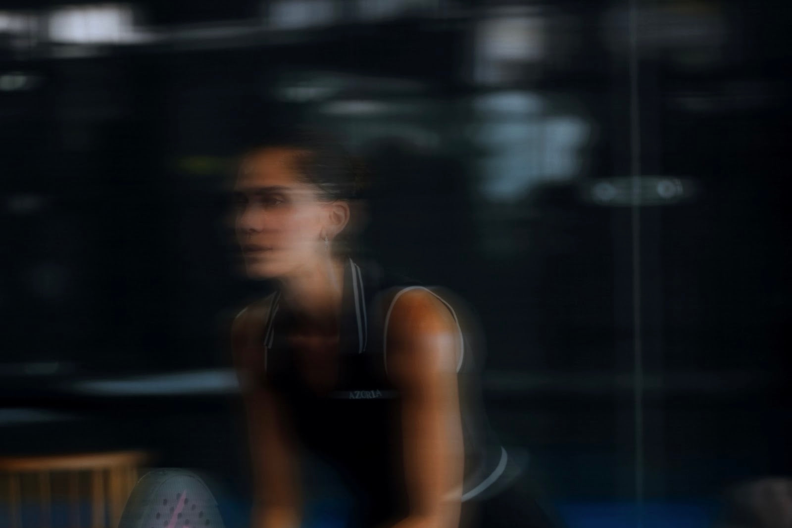 A player preparing an underarm serve on a padel court at Azoria Padel Club in Uluwatu, Bali